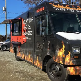 a black food truck with flames on it