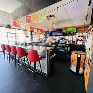a bar with red chairs