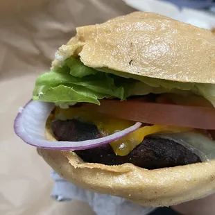 a hand holding a cheeseburger