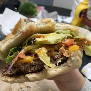 a hand holding a hamburger