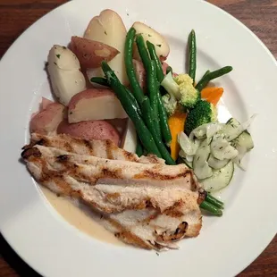 Broiled rainbow trout with a mound of veggies.