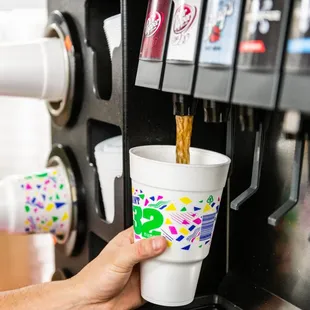 a hand reaching for a cup of coffee