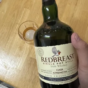 a hand holding a bottle of redbreast