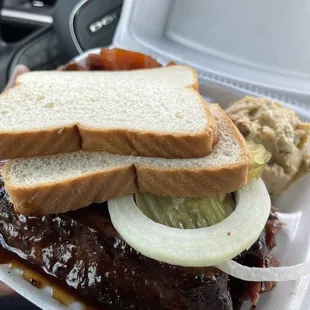 a bbq sandwich in a styrofoam container