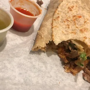 a burrito with a side of sauce