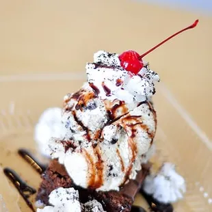 a chocolate sundae with whipped cream and a cherry on top