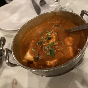 a pot of curry with a spoon in it
