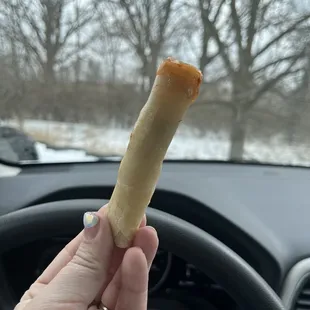 a person holding a pastry in their hand