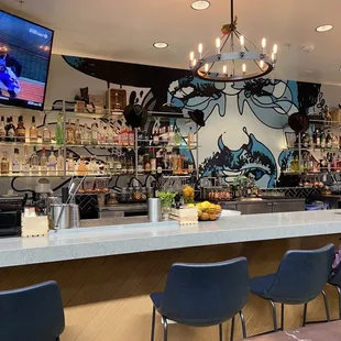 a bar with chairs and a television