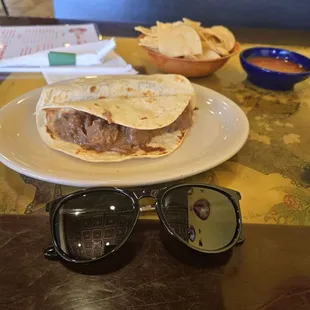 Sunglasses next to tacos for scale.