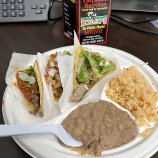 Chicken, pork, and beef tacos with rice and beans