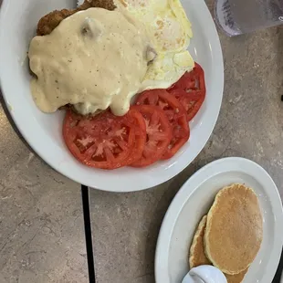 Country fried steak &amp; eggs with tomato slices and pancakes