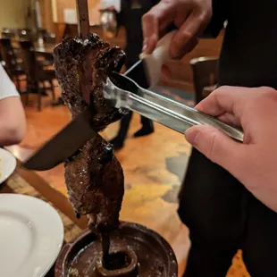 a steak being cooked on a skewer