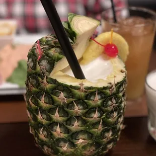 a pineapple drink with a straw and a garnish