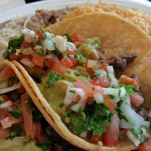 Two carne asada tacos with rice and beans!