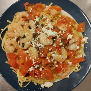 a plate of pasta with shrimp and tomatoes