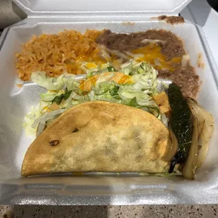 Two shredded beef tacos , with rice and beans