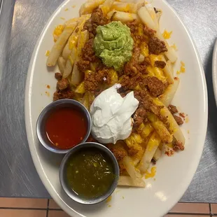 Adobada fries with a side of guacamole, sour creams and homemade salsas!