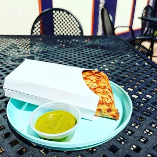 a slice of pizza and a bowl of sauce