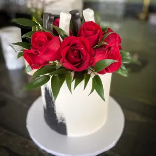 a wedding cake with red roses