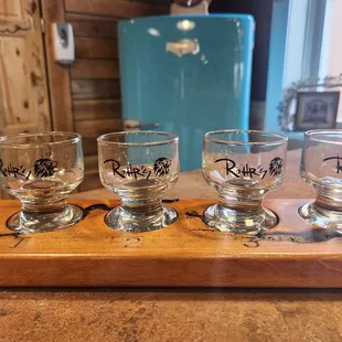 four glasses on a wooden tray