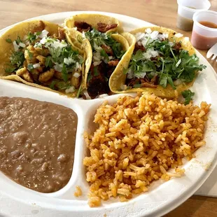 Three assorted tacos with rice and beans