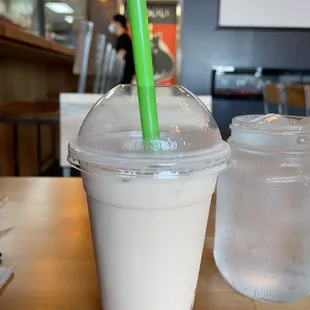 a plastic cup with a green straw
