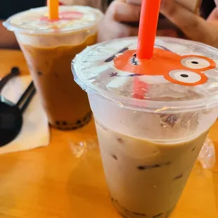 two iced drinks with orange straws