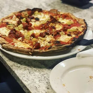 Pizza with pepperoni and banana peppers.