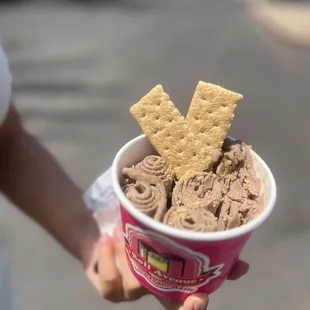 a person holding a cup of ice cream