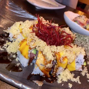 a plate of sushi and a bowl of salad