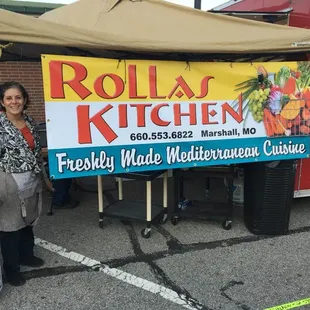 a woman standing in front of a food truck