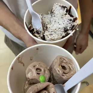 a person holding two bowls of ice cream
