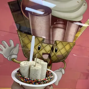 Presenting the whatchamacallit rolled ice cream in a sprinkles and chocolate coated waffle bowl