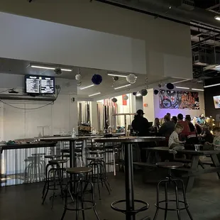 people sitting at tables and watching televisions