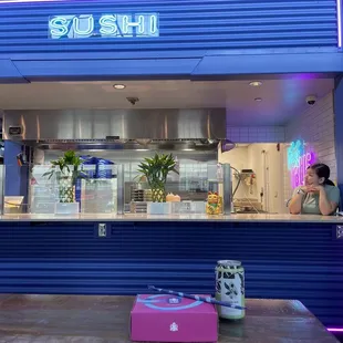 a woman standing in front of a sushi restaurant