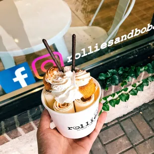 a hand holding a cup of ice cream