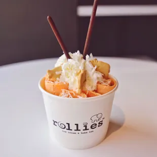 a cup of ice cream with bananas and whipped cream