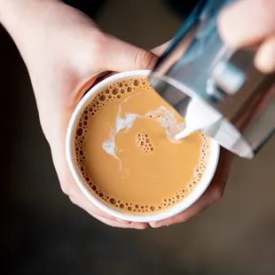 a person pouring a cup of coffee