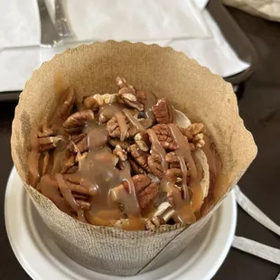 Cinnamon roll with caramel drizzle, pecans, coffee cream cheese