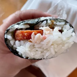  hand holding a piece of sushi