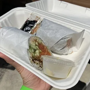  a hand holding a container of food