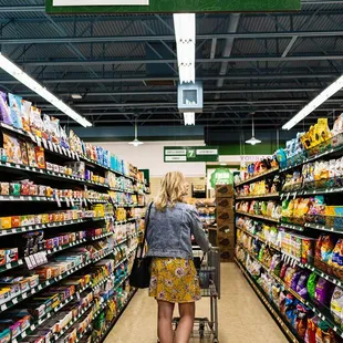  woman pushing a shopping cart through the aisle