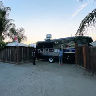 wo people standing in front of a food truck
