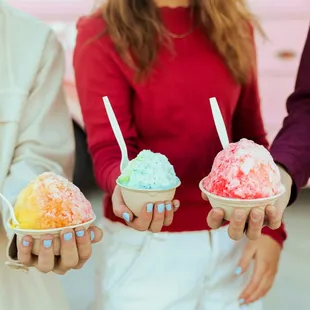 three people holding ice cream cones