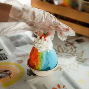 a person's hand holding a cupcake