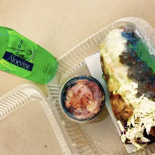 a plastic container with a sandwich and a bottle of water