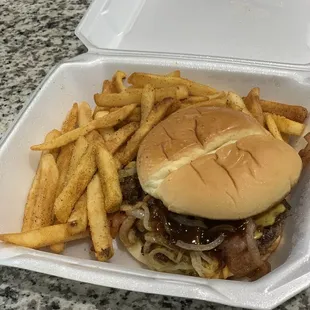 a hamburger and fries in a styrofoam container