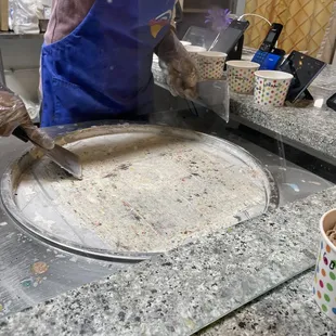 a person in a blue apron making a pie