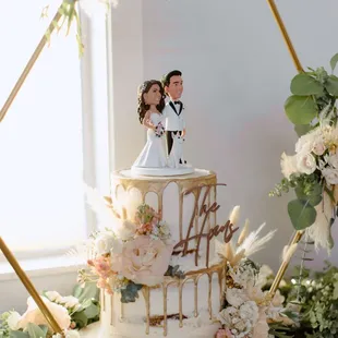 a bride and groom on top of a wedding cake